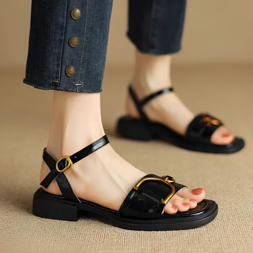 Women's black leather thick-soled sandals with a round toe and buckle closure on a white background