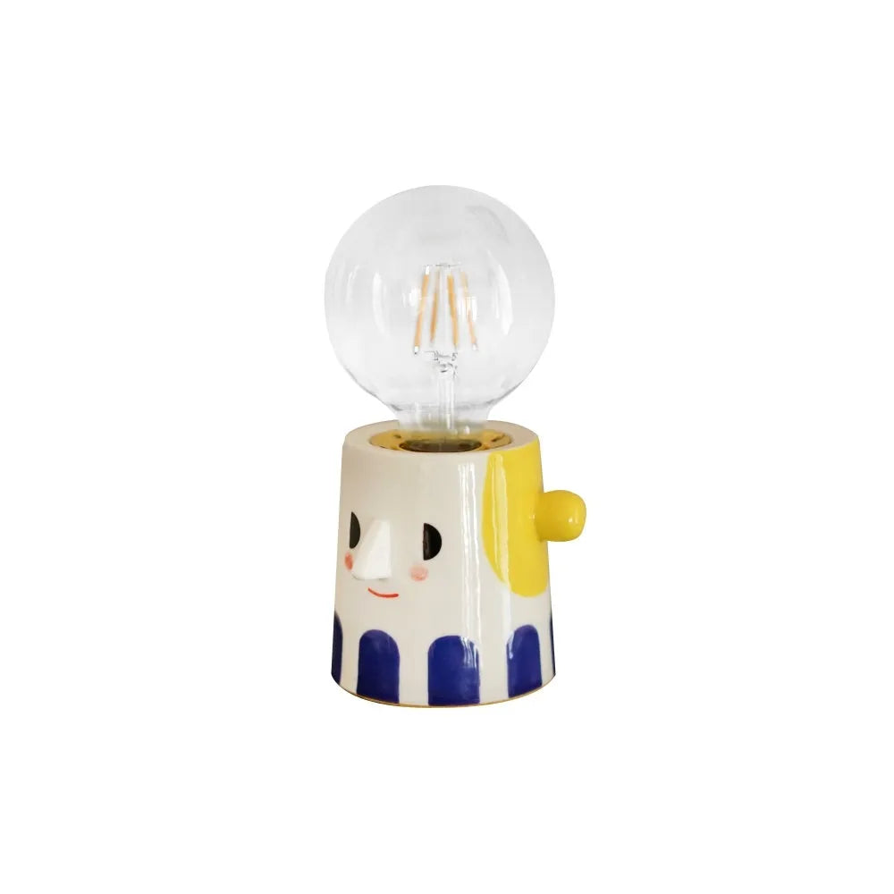 Handmade ceramic lamp with ball headlight design on wooden surface