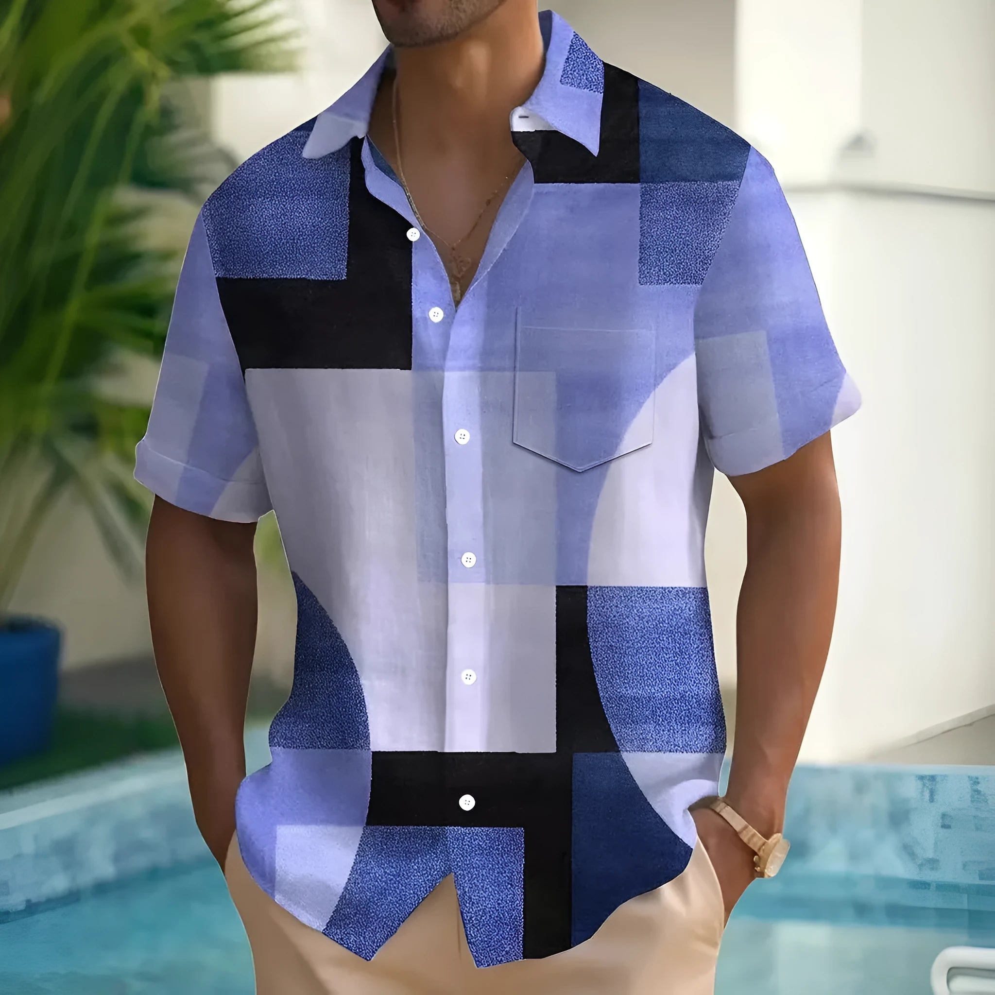 Man wearing a short sleeve cardigan with a blue and white retro geometric square print pattern.