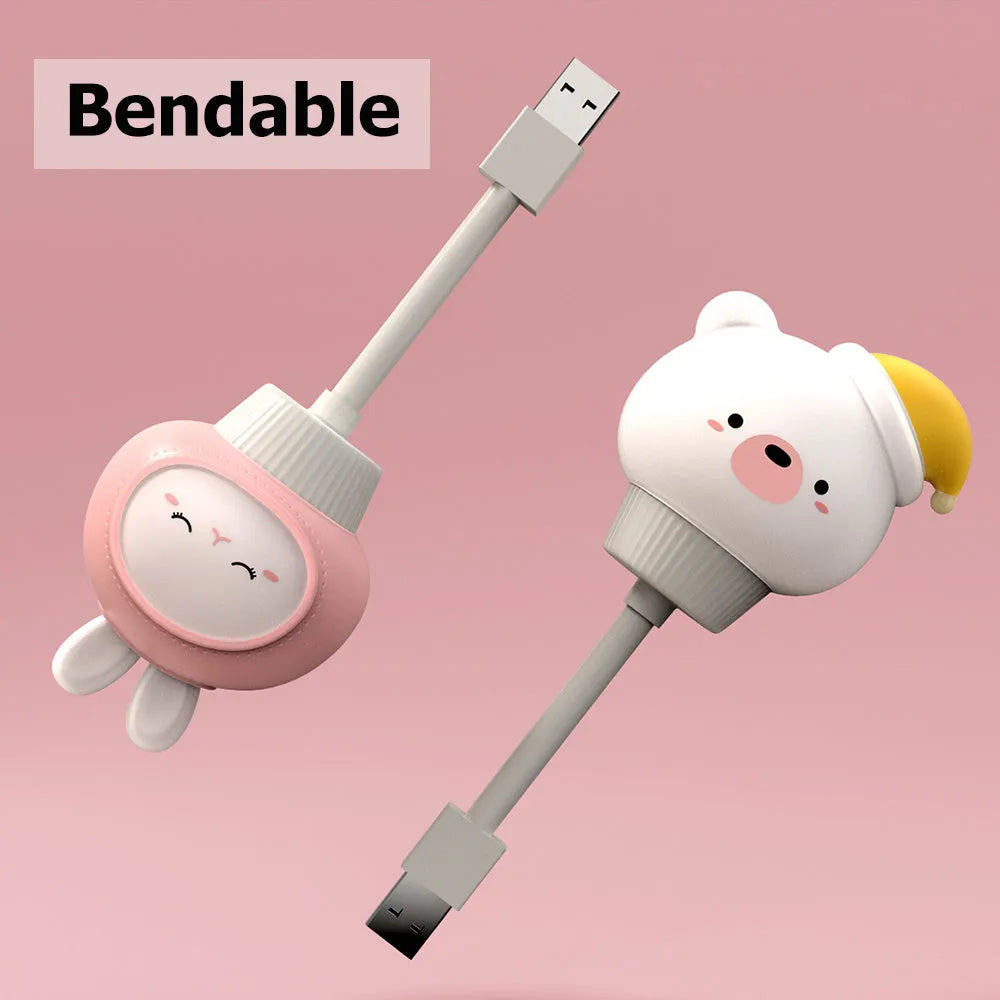 Cartoon animal USB portable LED night light with remote control on a bedside table.