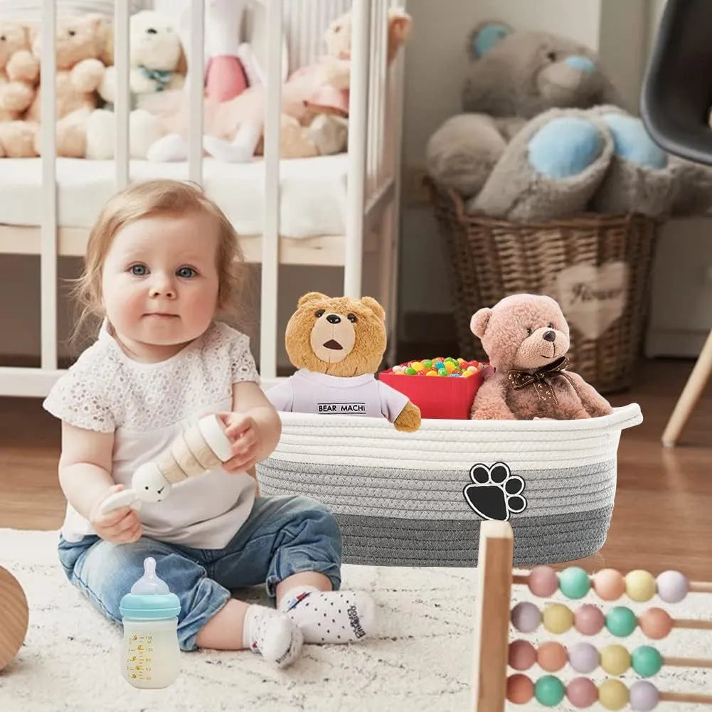 Handmade light beige woven cotton rope storage basket with a wooden handle.