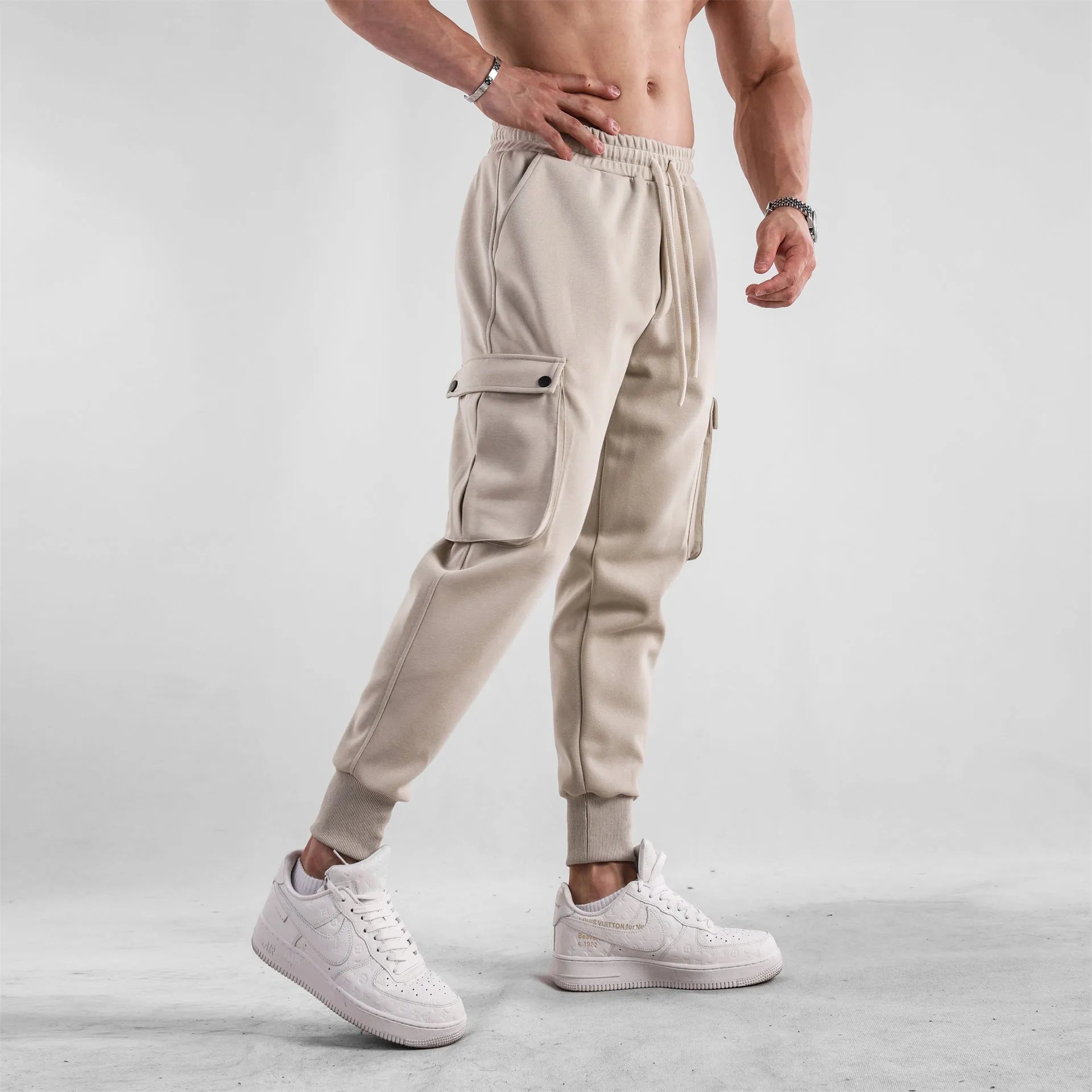 Men's loose fit cotton sports trousers with ankle ties in apricot colour showing multiple pockets