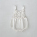 Beige baby romper with flower cutout strap and matching hat on a baby girl