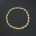 Flower-shaped cross tennis chain bracelet in gold alloy on white background showing diamond and geometric detailing