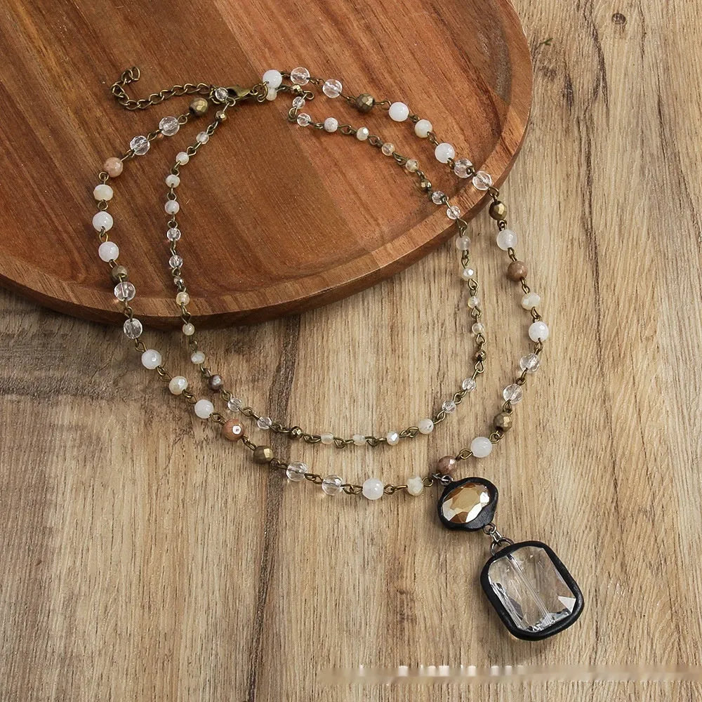 Beige and blue two-layer tribal style necklace with glass pendant and stone accents on adjustable chain