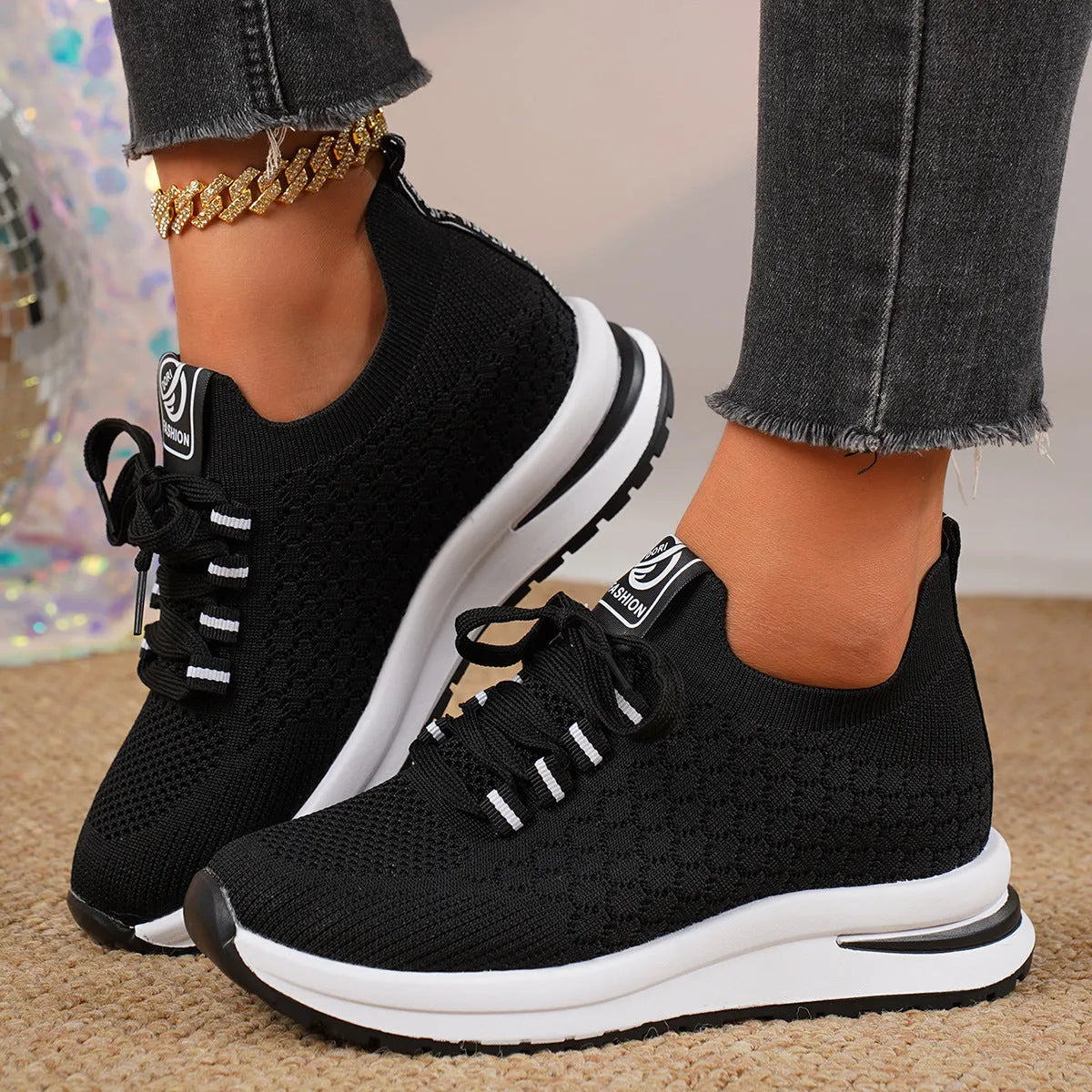 Women's black lace-up mesh sneakers with a flat rubber sole and round toe on a white background.