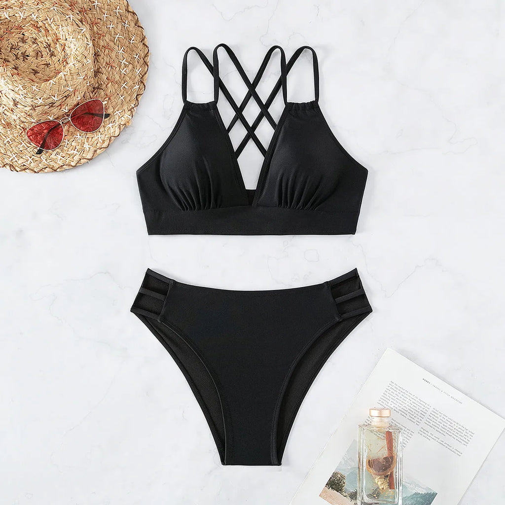 Women's black V-neck halter bikini with split shorts on a neutral background.