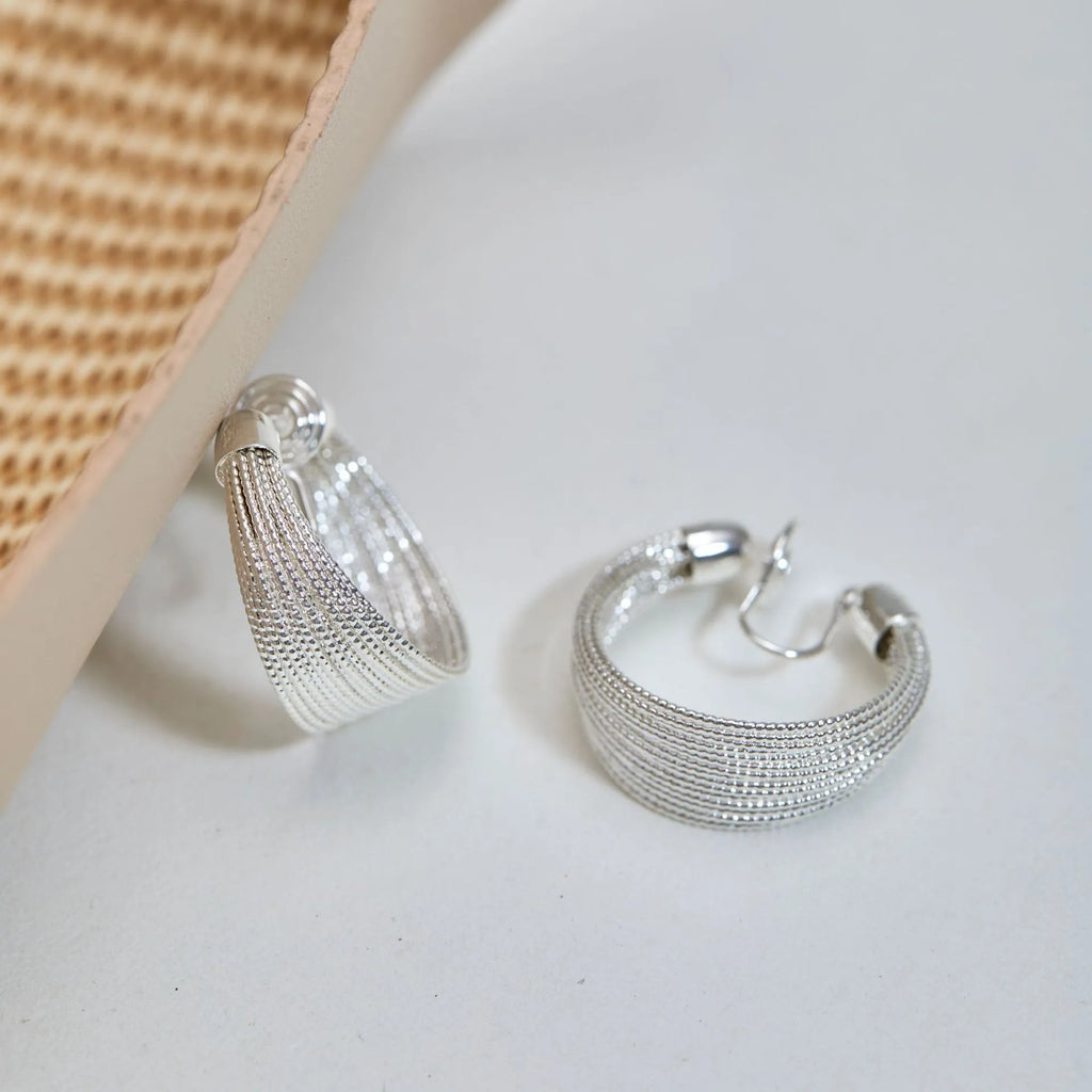 Geometric copper earrings with electroplated silver or gold finish, shown as stud and clip-on styles
