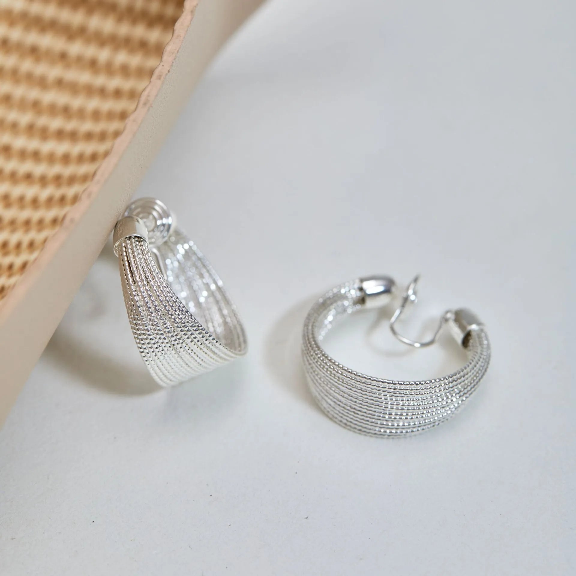 Geometric copper earrings with electroplated silver or gold finish, shown as stud and clip-on styles