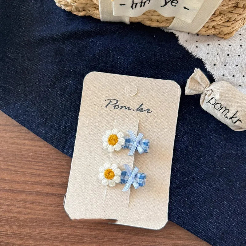 Children's denim handmade flower polka dot bow barrettes with triangle and duckbill clips on a light background