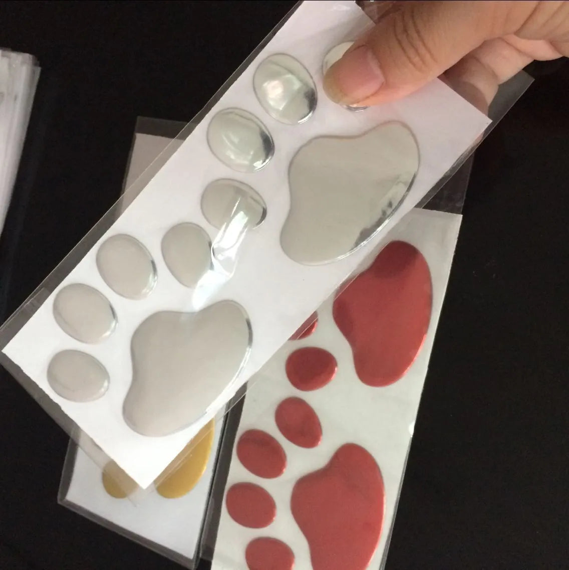 PVC hand-shaped car sticker with dog footprints in red, silver, gold, and black colour options.