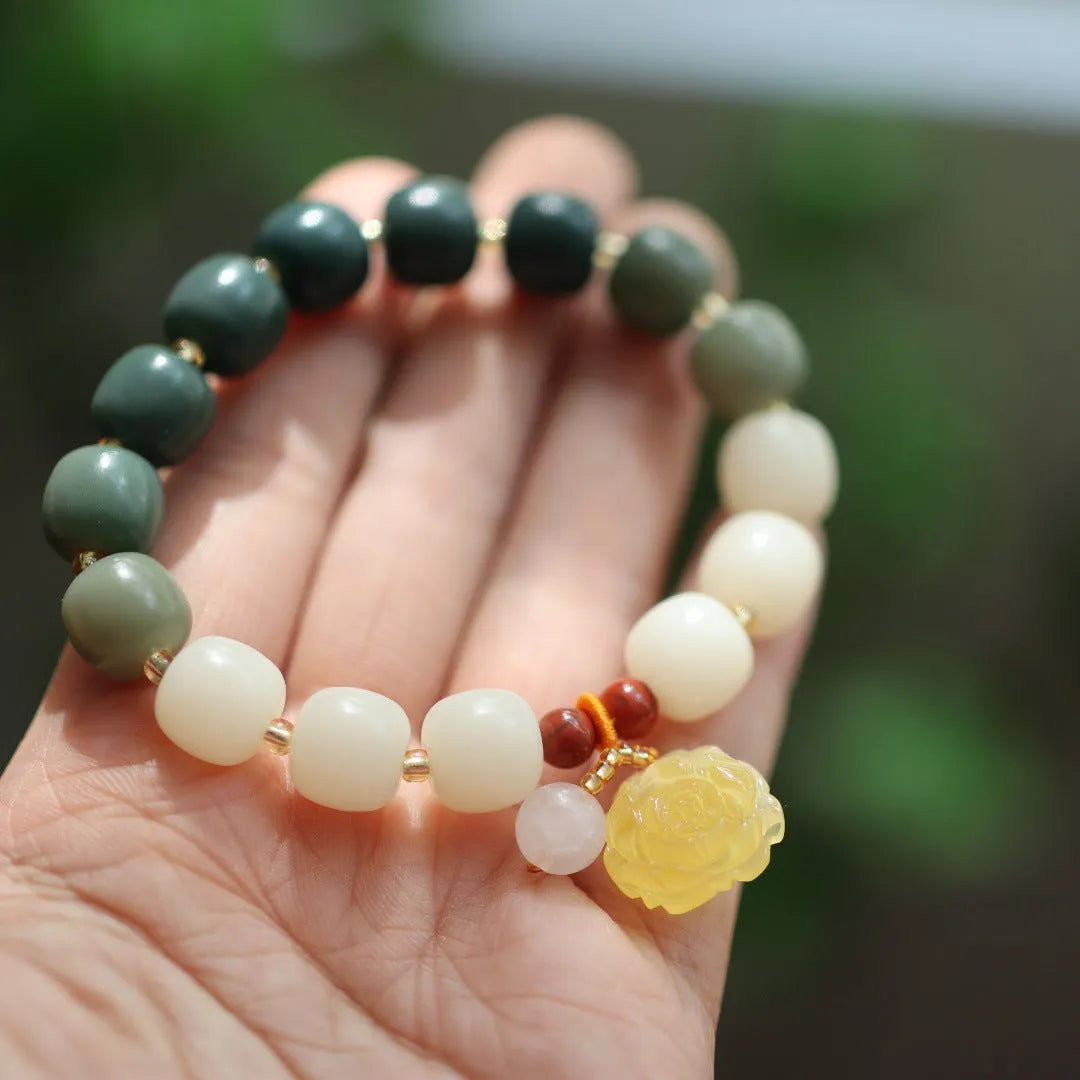 Close-up of a woven gradient white jade and Bodhi root bracelet with flower-shaped beads and a lotus accent.