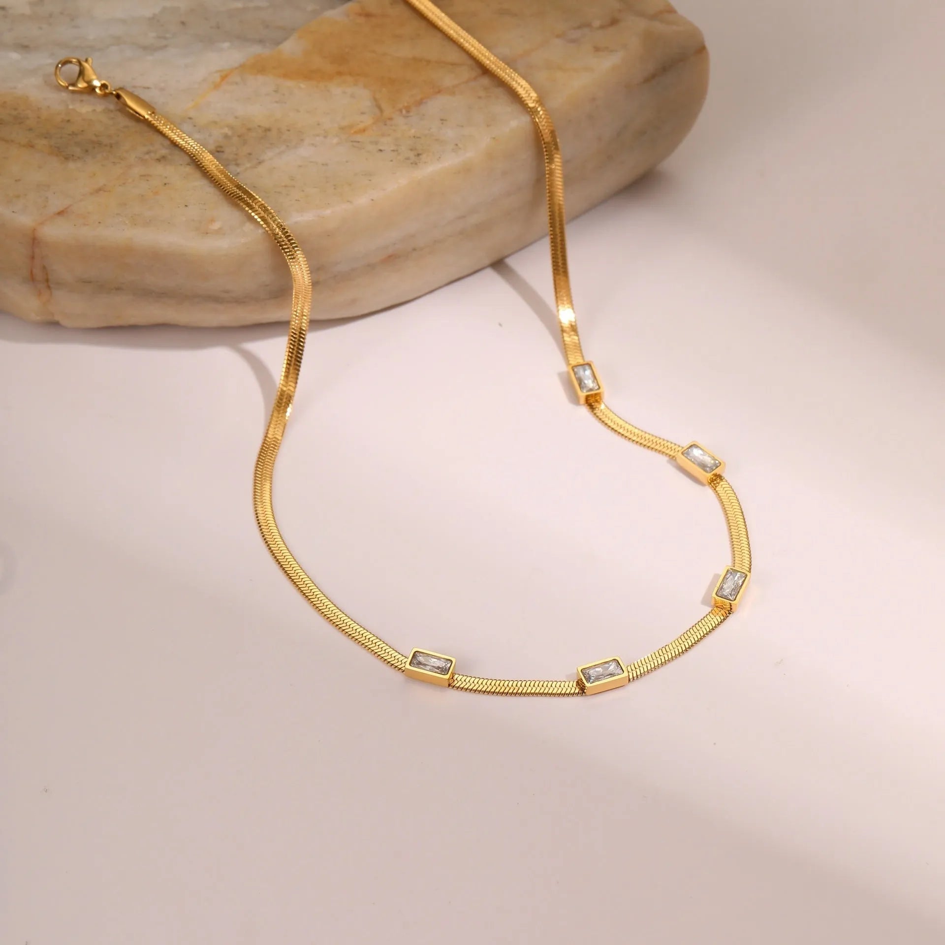 Retro geometric square zircon necklace on a flat snake chain in gold electroplated stainless steel.