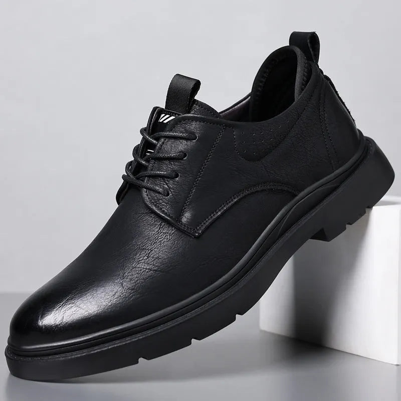Men's black and brown leather casual sneakers with sewing line detail on the cowhide upper and a rubber sole.