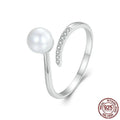Adjustable sterling silver ring with a white shell pearl centre on an open loop band.