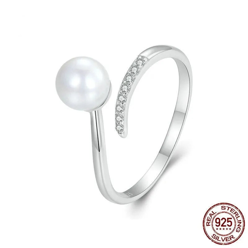 Adjustable sterling silver ring with a white shell pearl centre on an open loop band.