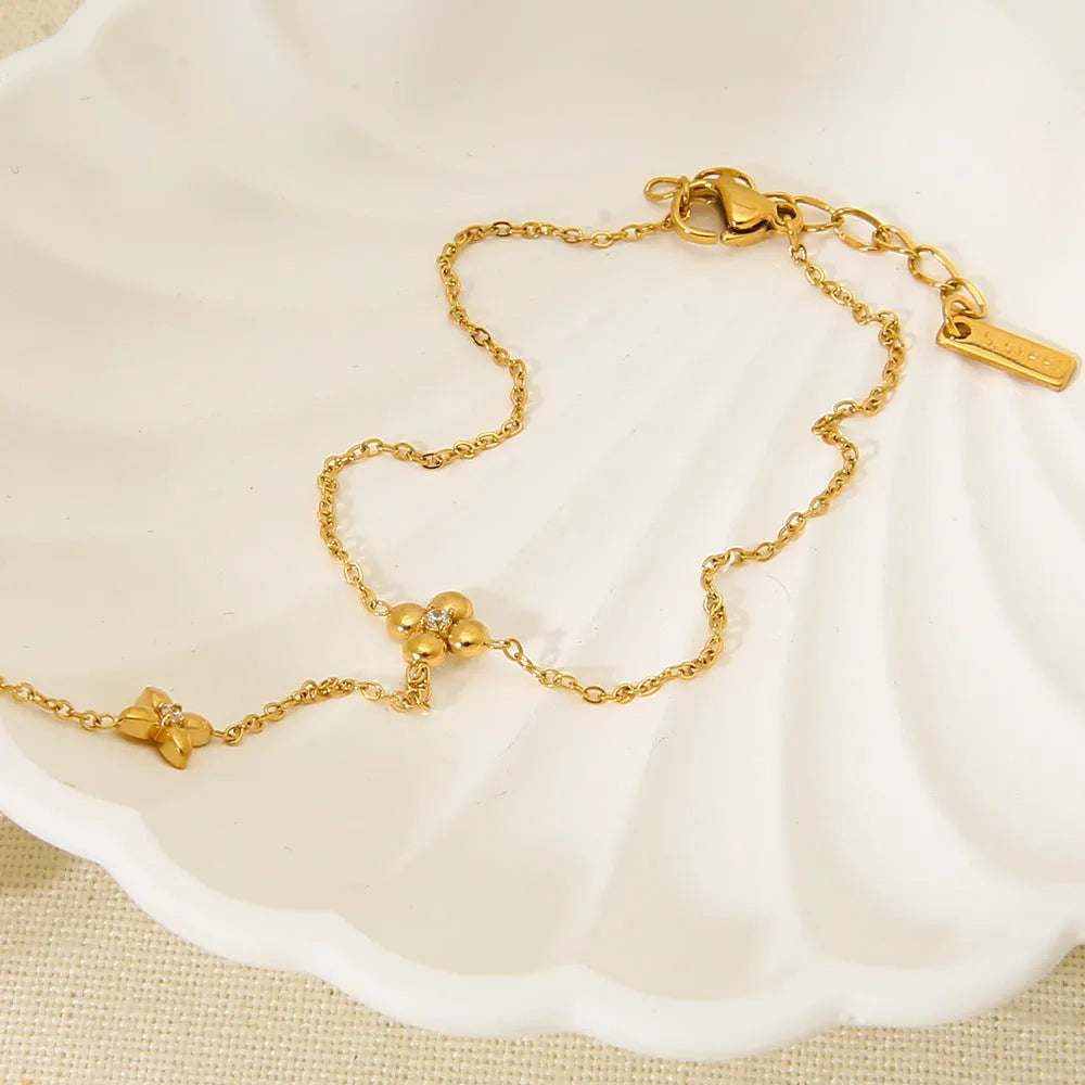 Gold-coloured stainless steel women's bracelet with geometric floral and eight-pointed star design.