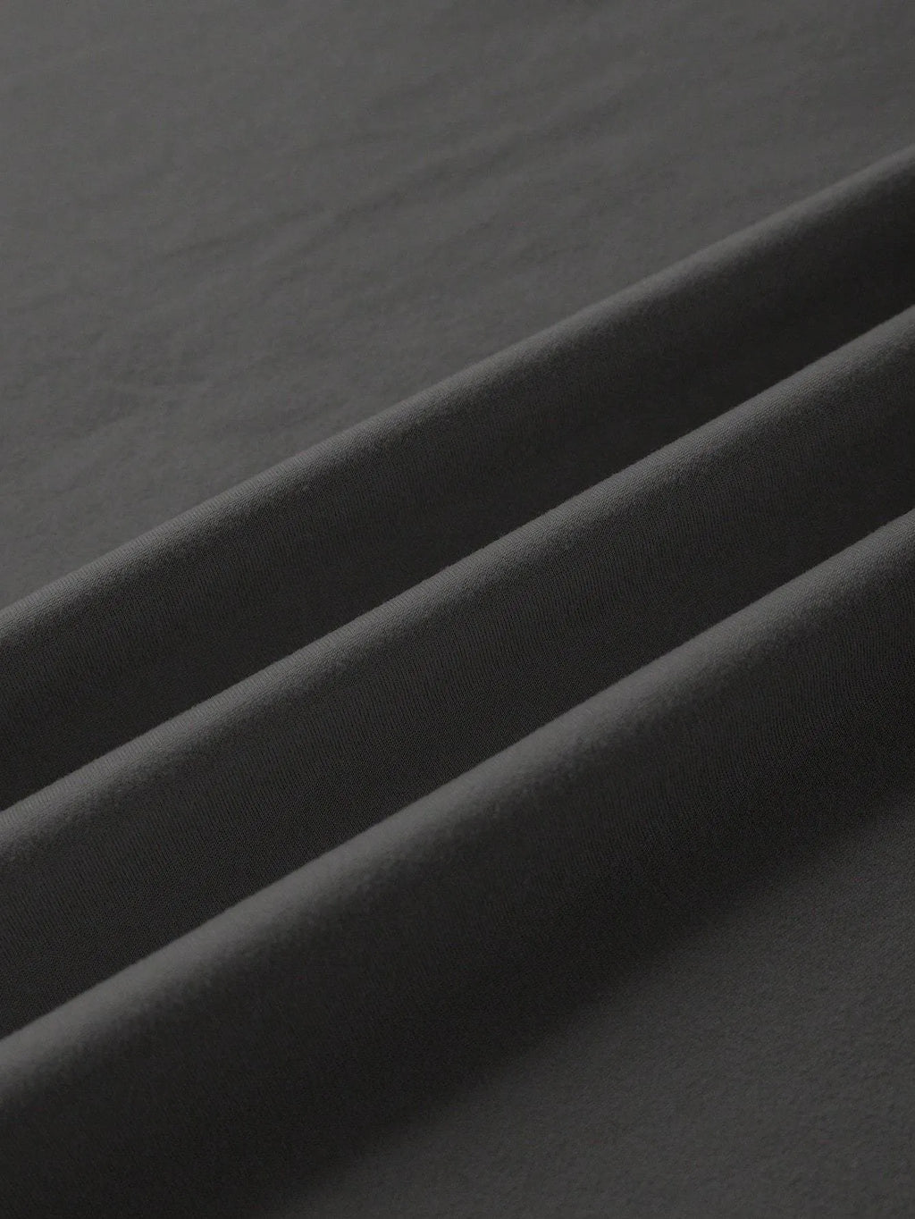 Loose fit cotton short sleeve t-shirt in black, shown on a hanger with round neck and straight cut.