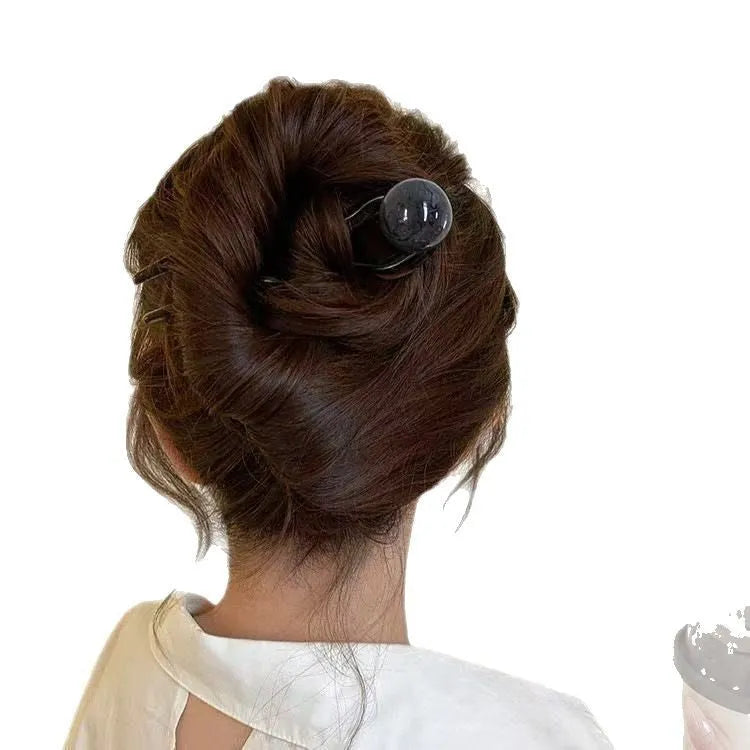 Acrylic U-shaped hair barrette with a small spherical decoration in a beige and caramel two-tone colour combination.