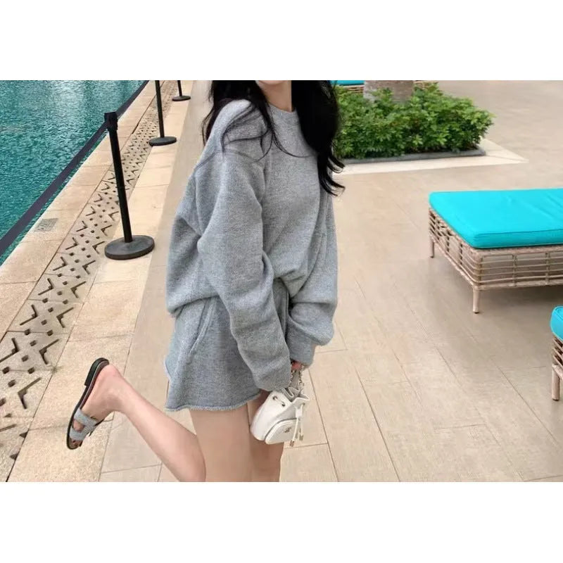 Women's knitted two-piece set showing loose-fitting long sleeve sweater and matching wide-leg shorts in neutral colour