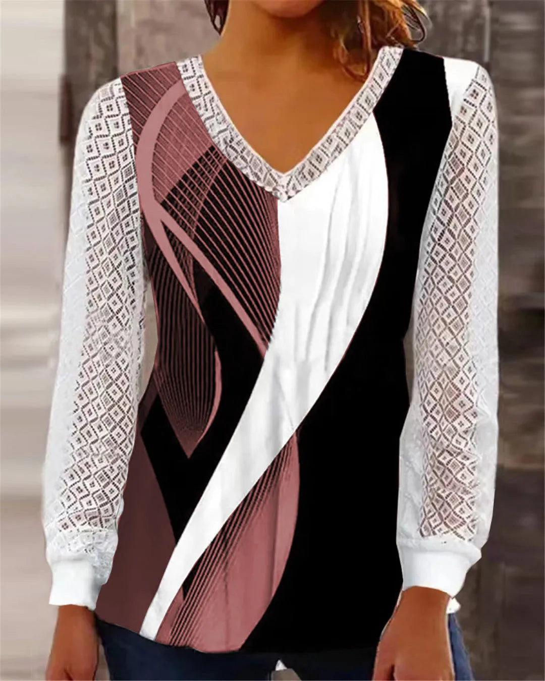 Purple loose V-neck top with lace print detail and long sleeves on a hanger.