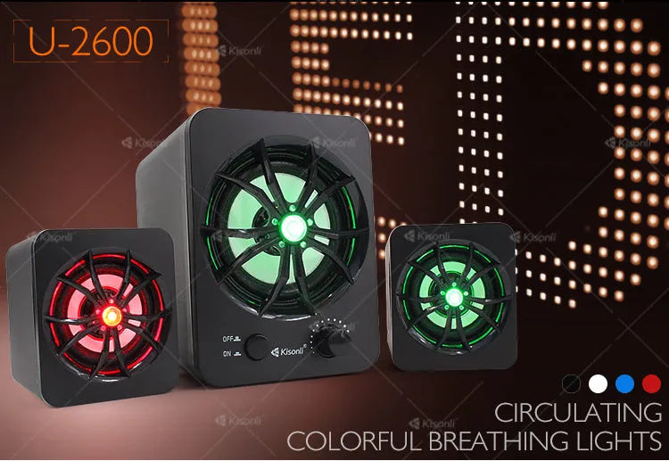 Green 2.1 USB computer speaker with colourful LED lights, showing USB and audio jack ports on a desktop.