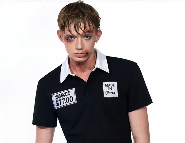 Black slim fit men's short sleeve polo shirt with embroidery detail on a hanger.