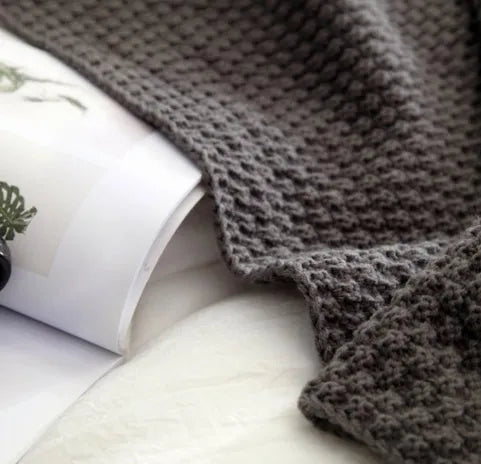 Nordic-style fringed knit ball acrylic blanket in beige colour, laid flat showing its 130x170cm size.