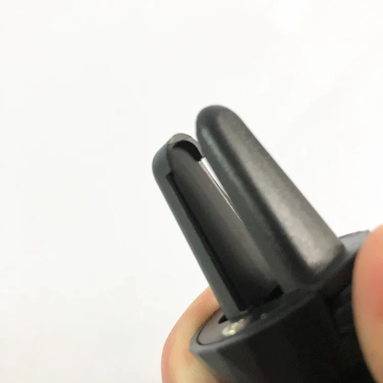 Black magnetic car phone holder mounted on car air vent with phone attached