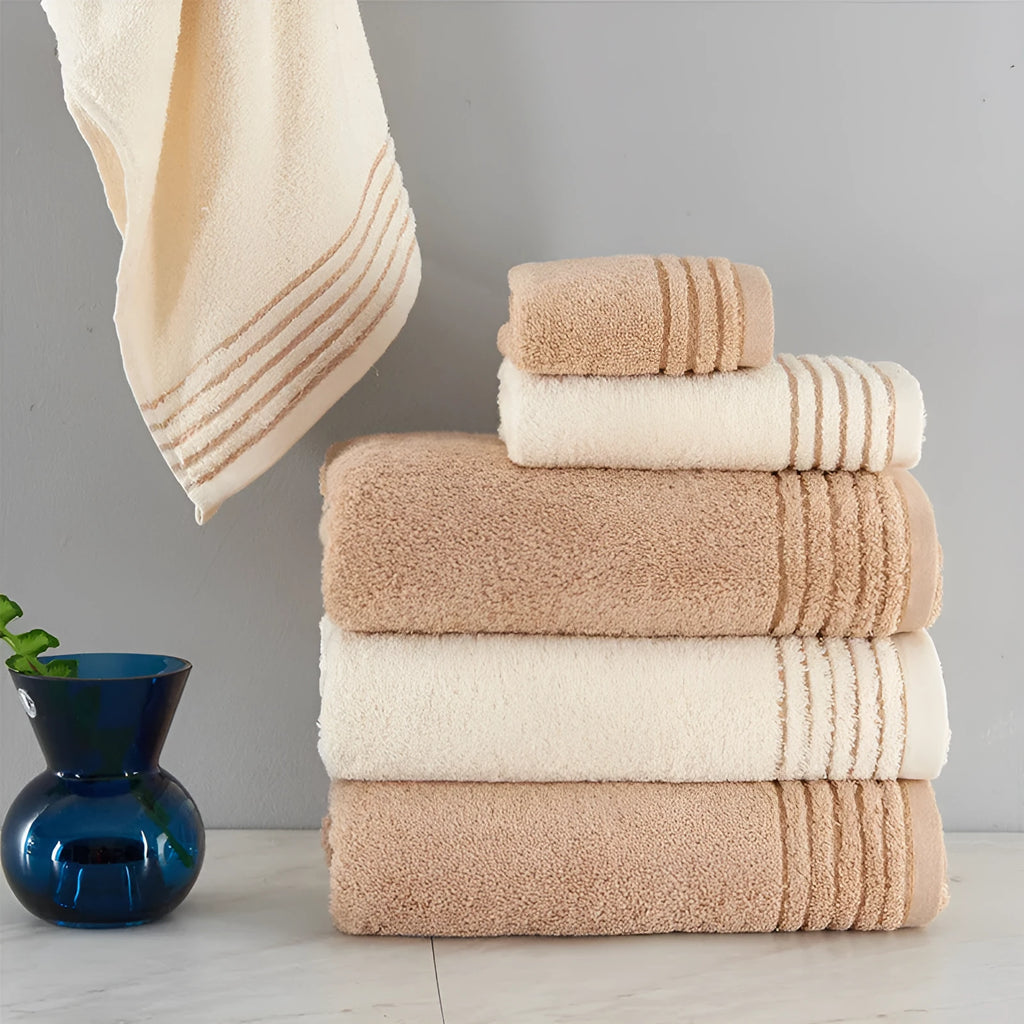 Beige and brown cotton towel set showing three sizes: square face cloth, hand towel, and bath towel.
