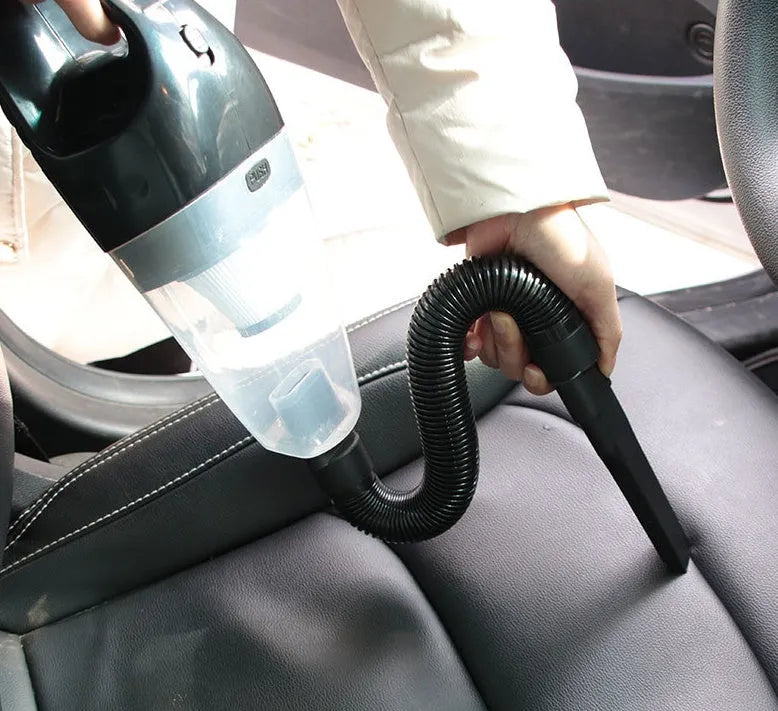 Orange handheld car vacuum cleaner with nozzle attached, showing compact design for vehicle use