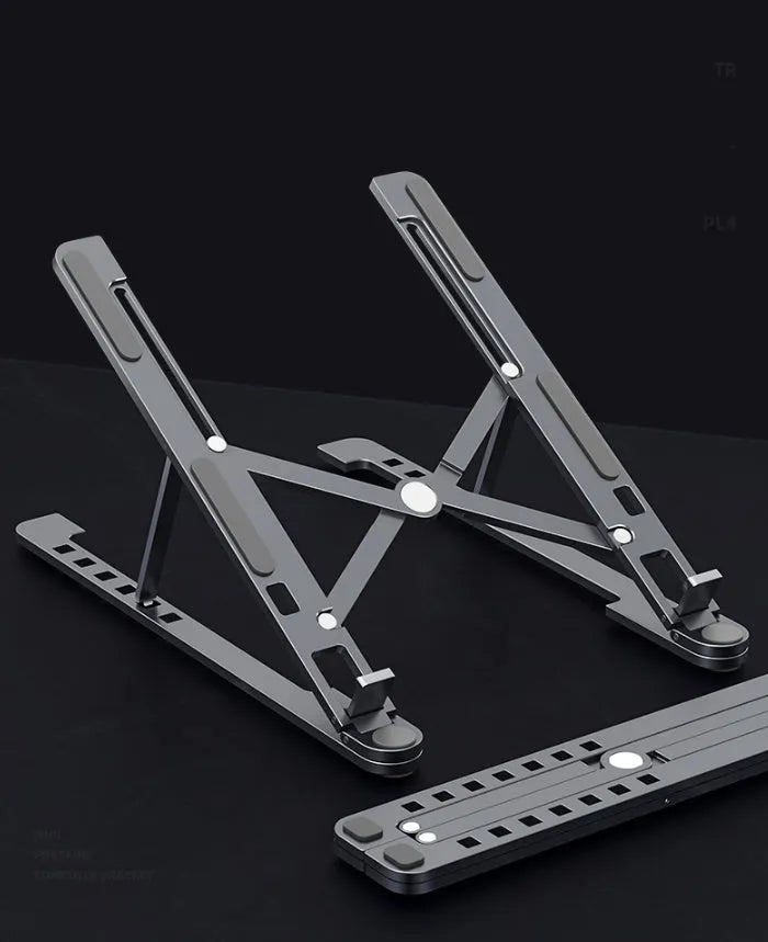 Deep grey foldable aluminium laptop stand holding a silver laptop at an angle.