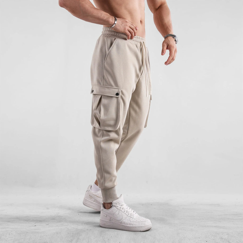 Men's loose fit cotton sports trousers with ankle ties in apricot colour showing multiple pockets