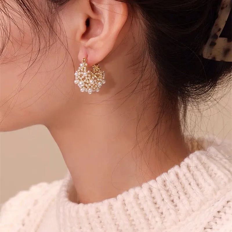 Women's gold copper earrings with floral basket design featuring small beads and pearl inlay detailing