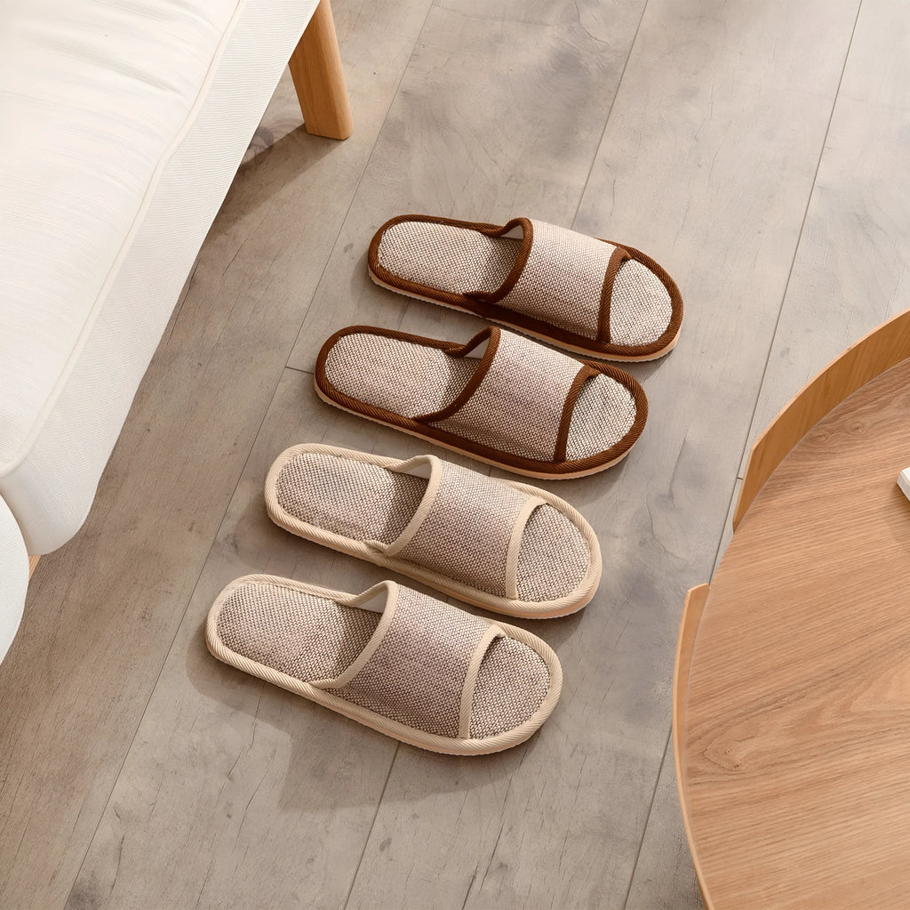 Women's open-toe linen slippers in light brown on a wooden floor, showing the breathable design and thickened sole.