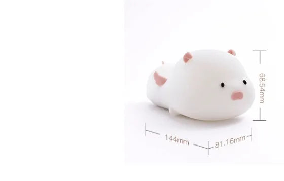 Pink silicone pig-shaped night light with touch control on bedside table