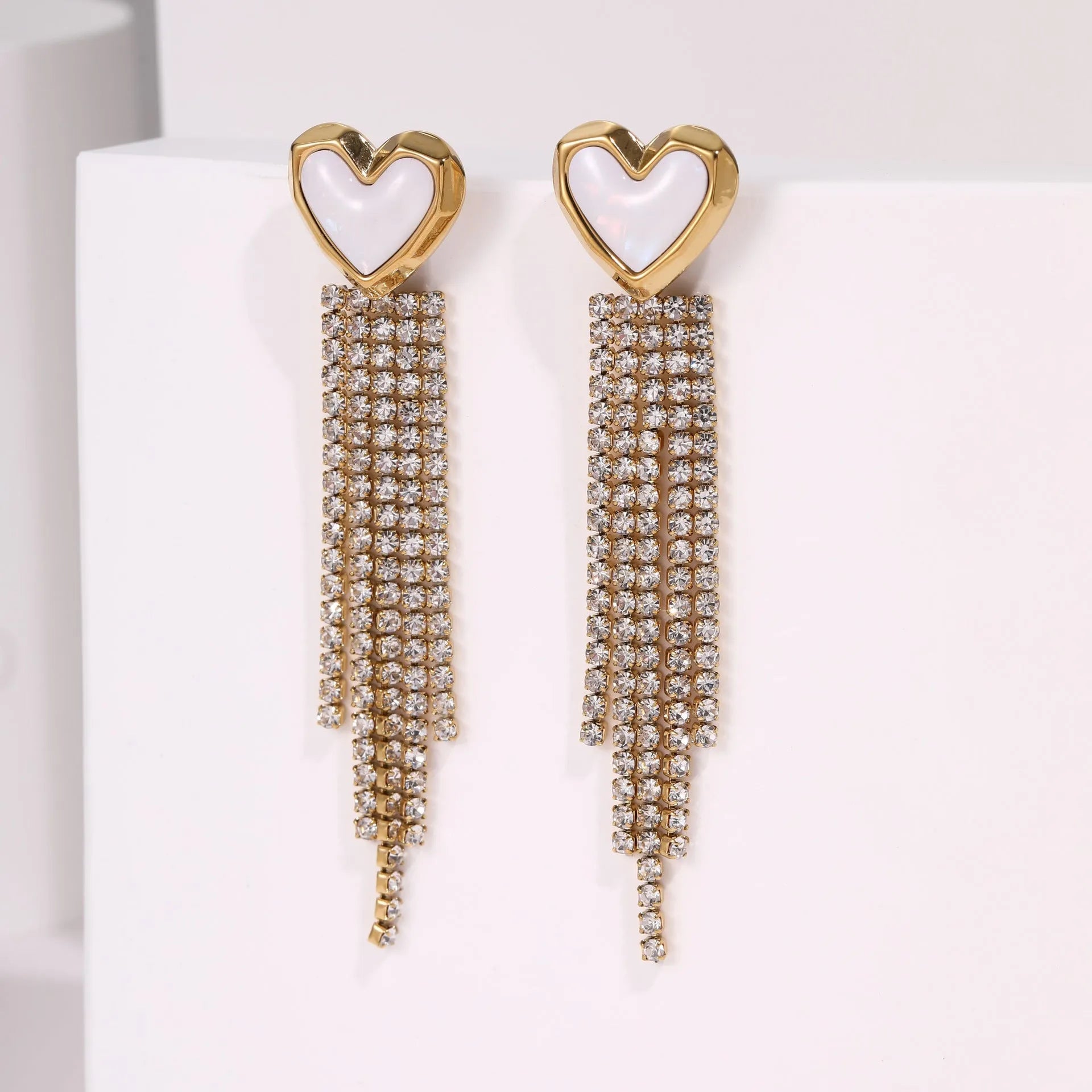 Gold electroplated stainless steel earrings with heart, star, and geometric shapes and a diamond tassel pendant.
