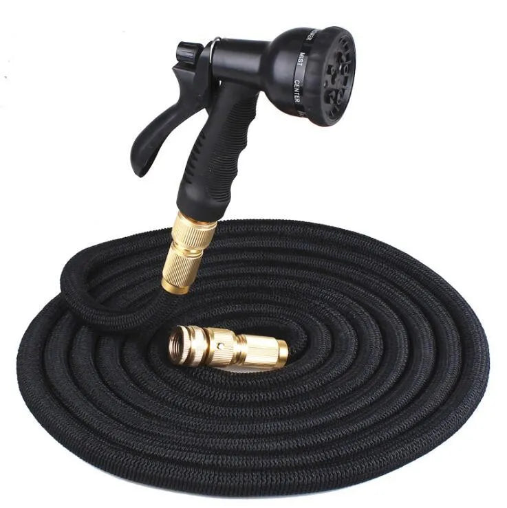 Expandable magic flexible water hose in black laid on grass showing compact initial length and stretched working length