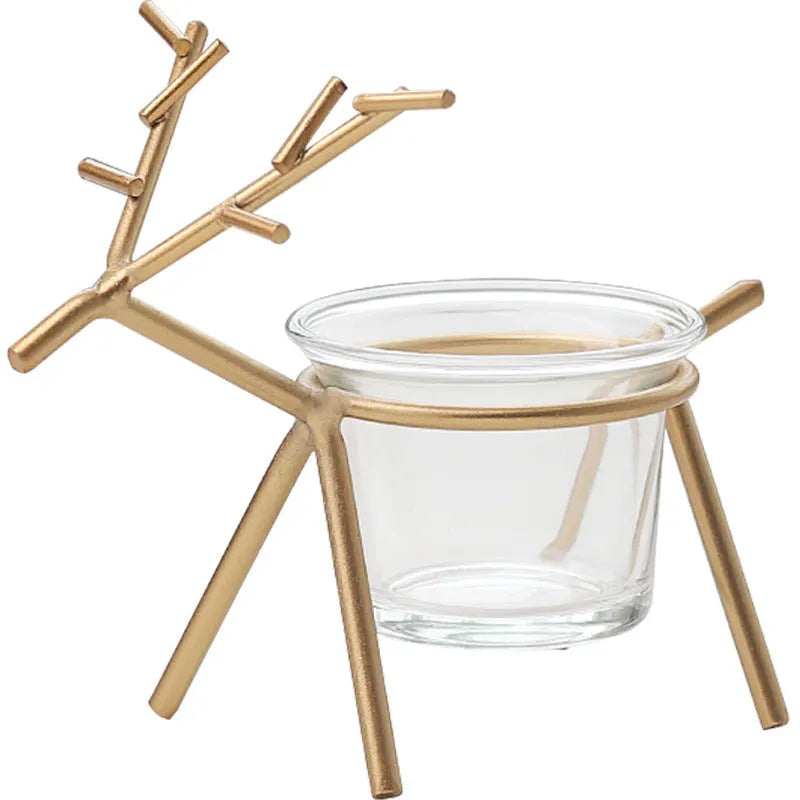Wrought iron fawn candle holder in gold finish with glass cup on a table