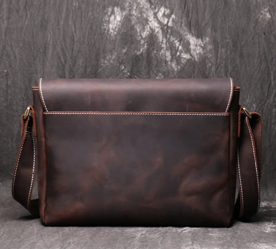 Brown vintage leather men's messenger bag with a shoulder strap showing internal organiser pockets.
