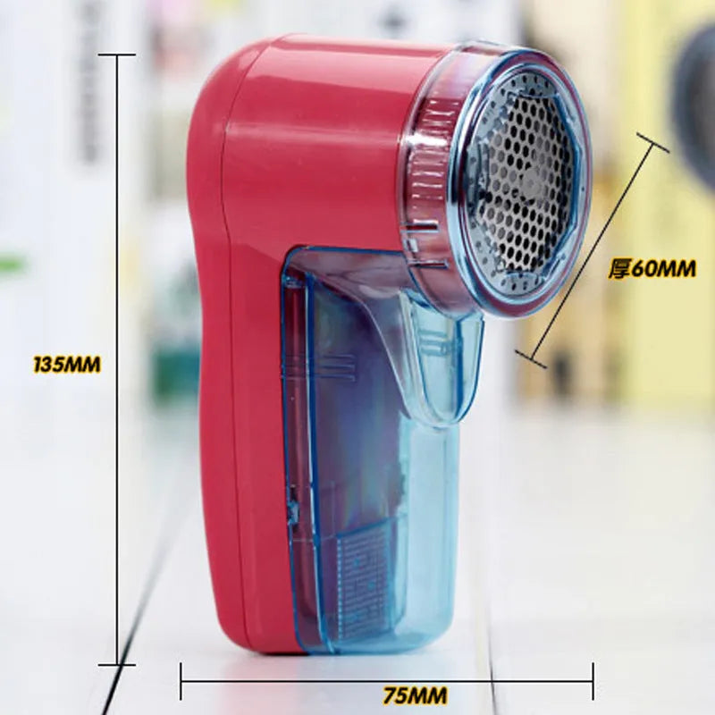 White portable electric lint remover for clothing on a table.