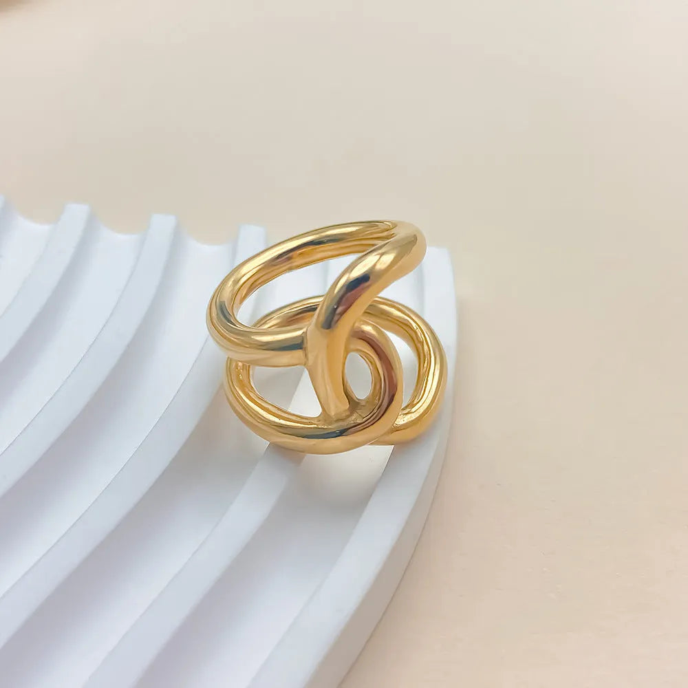 Women's stainless steel adjustable ring with knotted detail in gold or steel colour on a grey background.