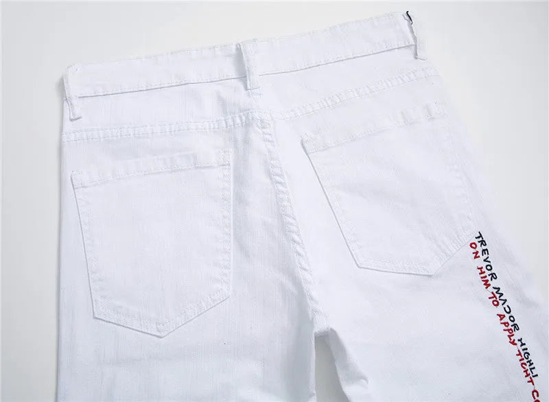 White shredded embroidery jeans in cotton denim, sizes 29-38, with ripped and embroidered details.
