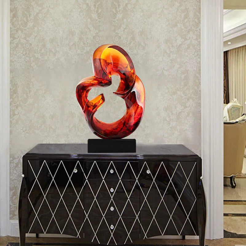 A transparent resin sculpture ornament in a modern style, shown in blue and orange red colour options.