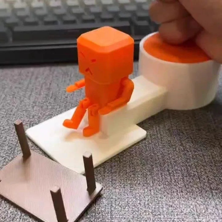 Orange plastic table turning decompression toy measuring 16cm long on a desk