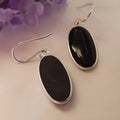 Women's geometric drop earrings with oval black agate pendant in silver setting
