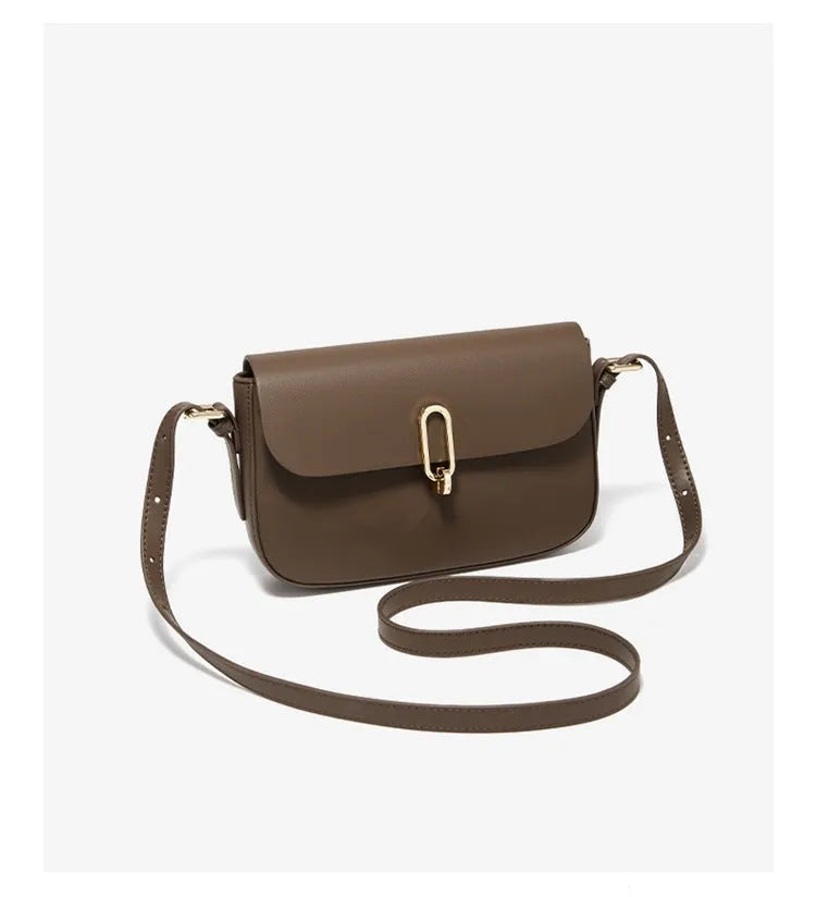 Black square leather messenger bag with shoulder strap showing lock closure and urban design