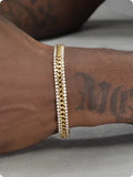 Gold tennis bracelet with artificial gemstone inlay on wrist, showing hip hop style unisex design