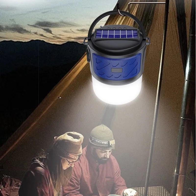Portable solar camping lantern speaker with Bluetooth, LED light, USB rechargeable, black colour, on outdoor lawn