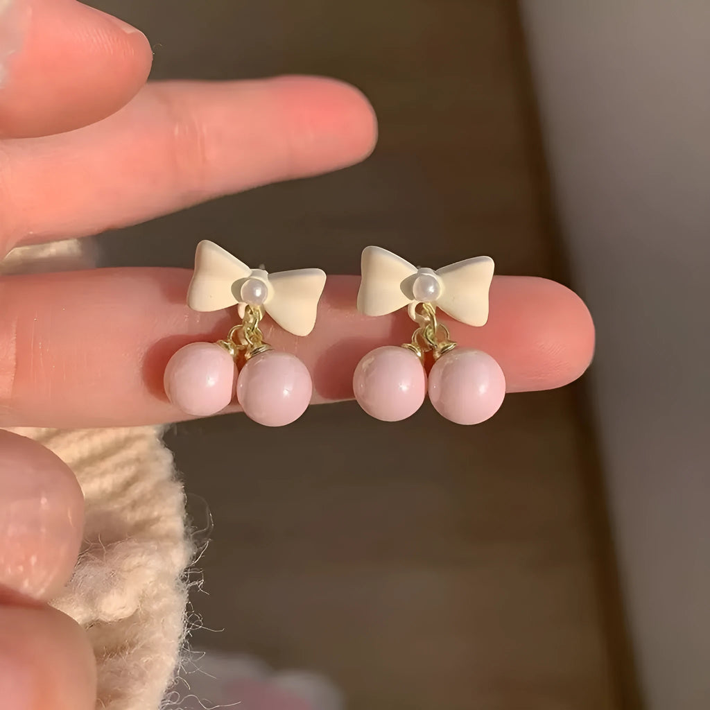 Pink alloy women's earrings with heart, pearl, and bow design, electroplated finish, sold as one pair